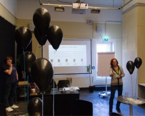 Schwarze Luftballons, Folie an der Wand, Attac-Aktive beim Politischen Frühstück