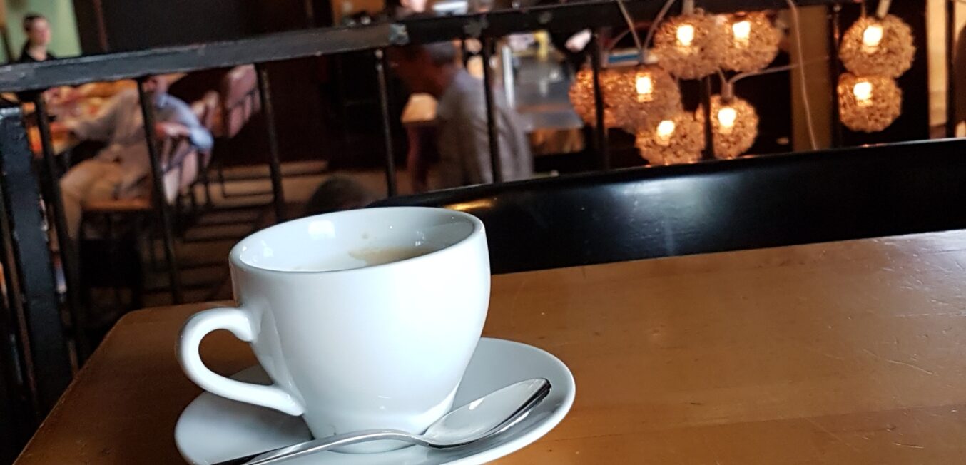 Kaffeetasse und im Hintergrund die zakk Kneipe
