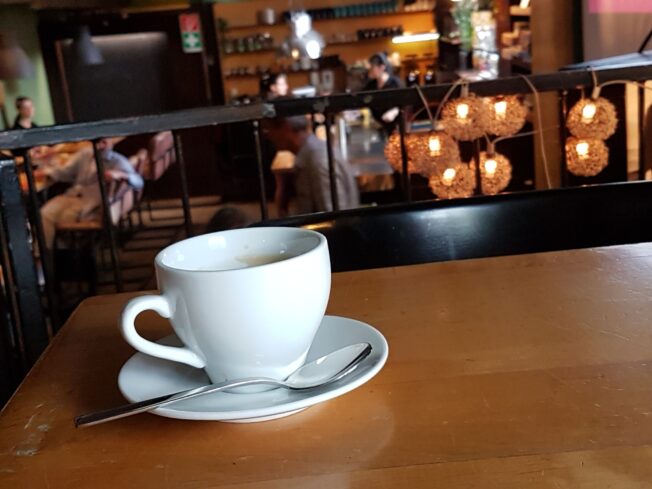 Kaffeetasse und im Hintergrund die zakk Kneipe